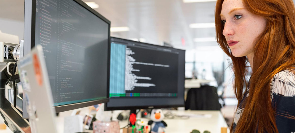 Woman working on computer at desk. 